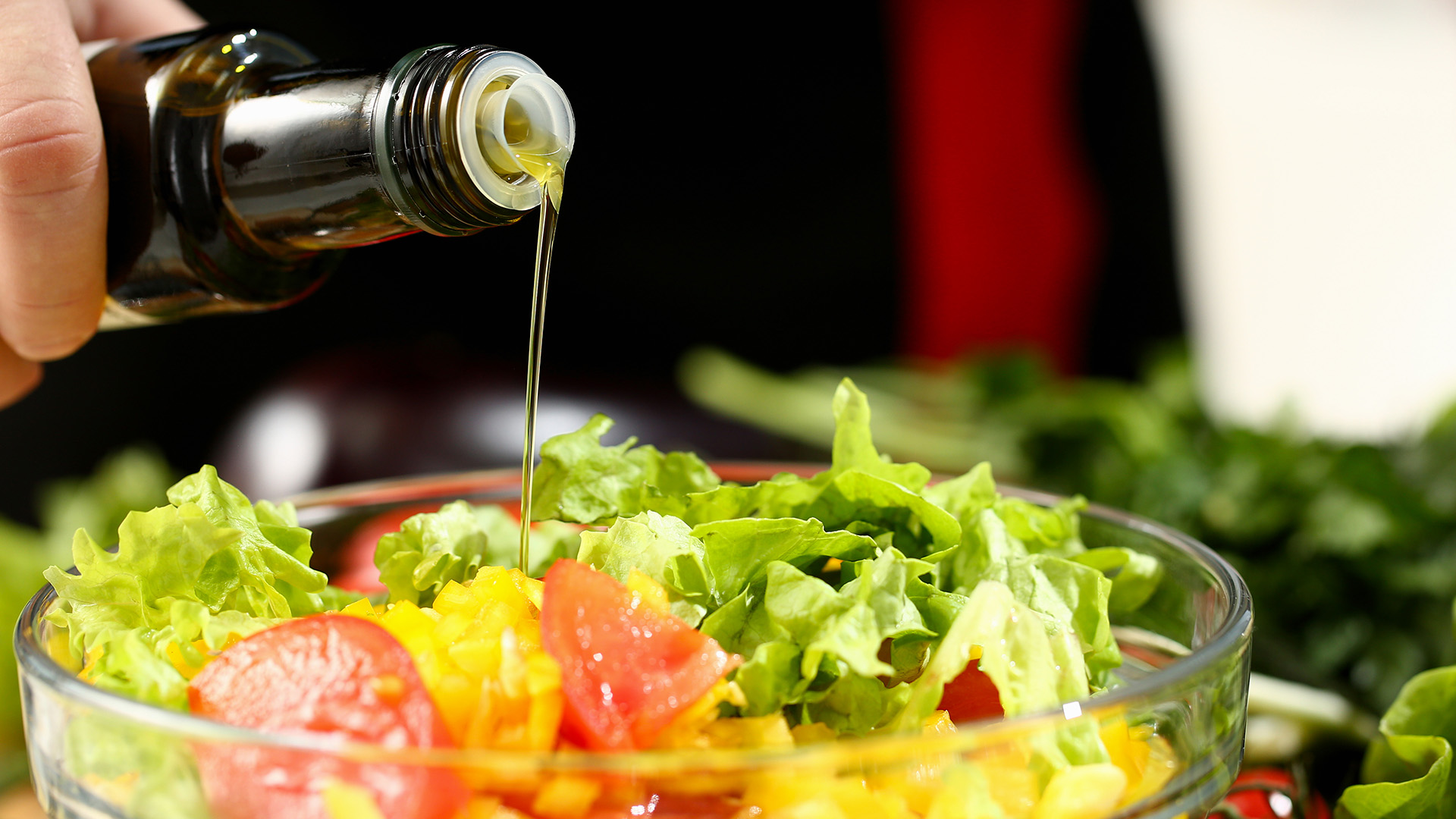 cuoco condisce insalata con olio extravergine di olive calabresi