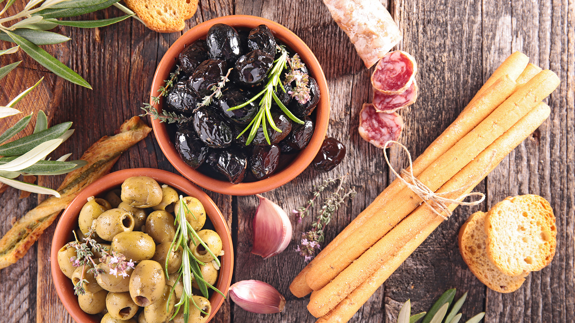antipasto con olive schiacciate alla calabrese, olive verdi, salumi affettati e pane